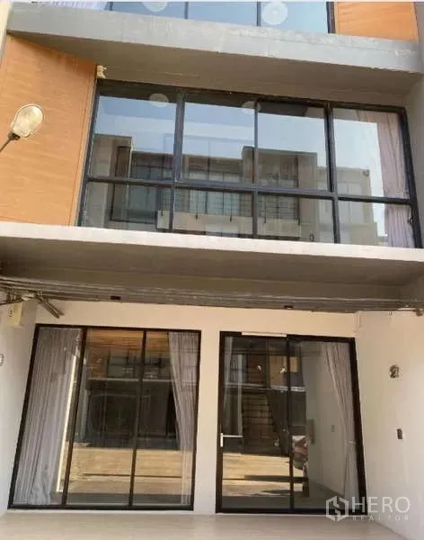 Home Office for rent or sale - Modern home office facade with wide glass sliding doors and upper balcony windows.