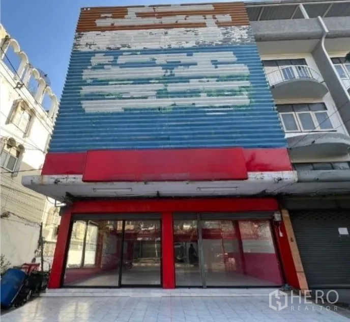 Shophouse for rent in Suan Luang, Bangkok - Multi-storey shophouse with wide glass frontage and a large faded signboard.