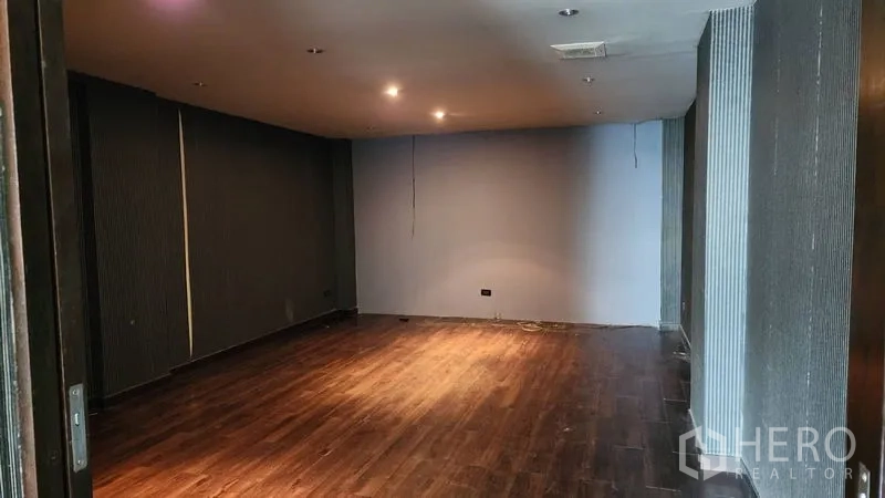 Shophouse for rent in Khlong Toei, Bangkok - Spacious multipurpose room with timber floors and recessed lighting.