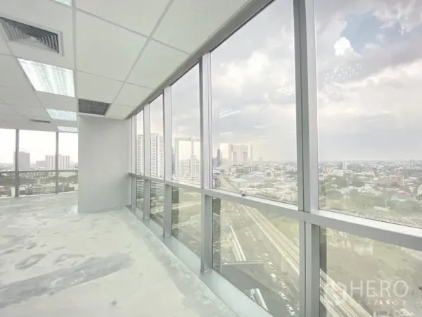 Office Space for rent in Chatuchak, Bangkok - Bright corner office with full-height glass windows and a wide Bangkok skyline view above transit tracks.