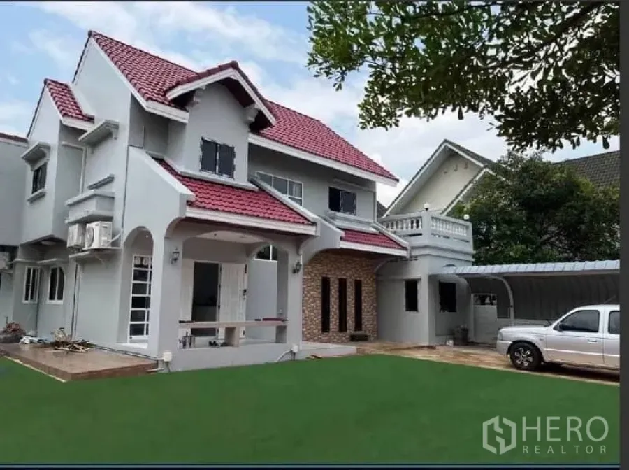 บ้าน ให้เช่าในSamut Prakan - ด้านหน้าบ้านพร้อมหลังคาจอดรถ ลานจอด และสนามจัดสวน.