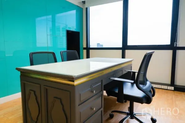 Office Space for rent - Private executive office with teal glass feature wall and city-view windows.