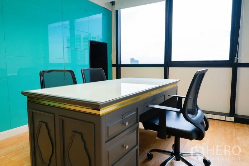 Office Space for rent - Private executive office with teal glass feature wall and city-view windows.
