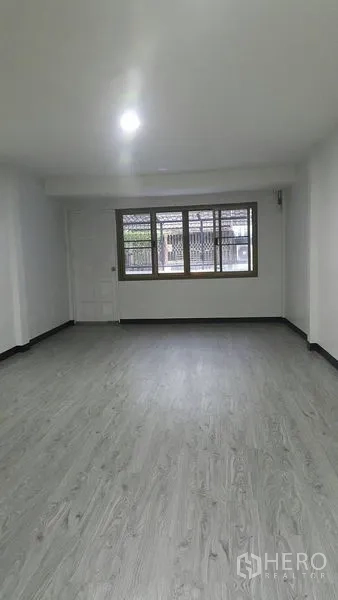 Shophouse for rent in Watthana, Bangkok - Spacious upper-floor room with large front windows and bright ceiling light.
