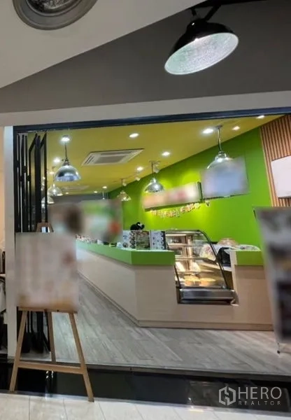 Retail Space for rent in Watthana, Bangkok - Glass-fronted retail shop interior with lime-green accent wall, pendant lights, wood-look flooring, built-in service counter and display case.