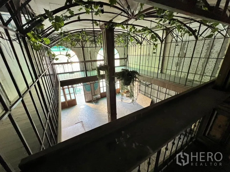 อาคารพาณิชย์ ให้เช่าในWatthana, Bangkok - มุมมองจากด้านบนของเอเทรียม มีต้นไม้แขวน หน้าต่างโค้ง และทางเดินชั้นลอย.