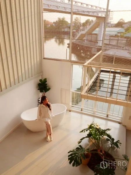 Townhouse for rent in Khlong Toei, Bangkok - Loft-style atrium with bathtub, indoor greenery and water views inside a Phra Khanong townhouse.