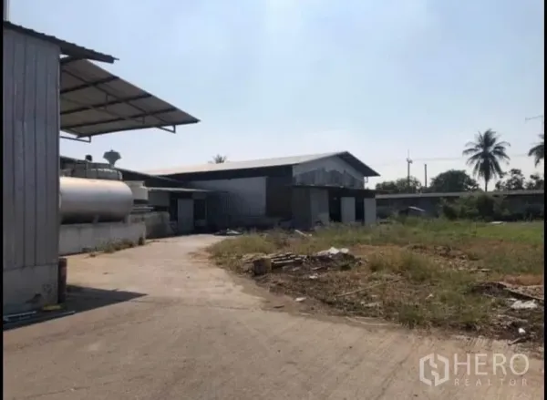 工厂 出租在Bang Khla, Chachoengsao - 工业区开放式水泥场地，金属厂棚、储罐与周边绿化。