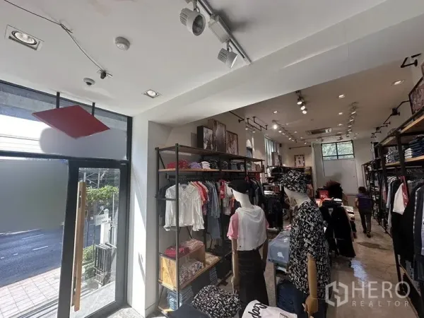 Retail Space for rent in Phra Khanong, Bangkok - Bright street-front retail interior with glass door, track lighting, clothing racks and polished concrete floor.