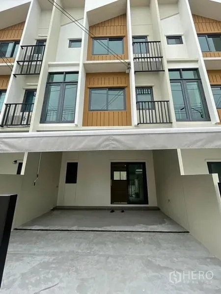 Townhouse for rent in Prawet, Bangkok - Modern three-storey townhouse exterior with covered two-car carport and small balconies in Prawet, Bangkok.