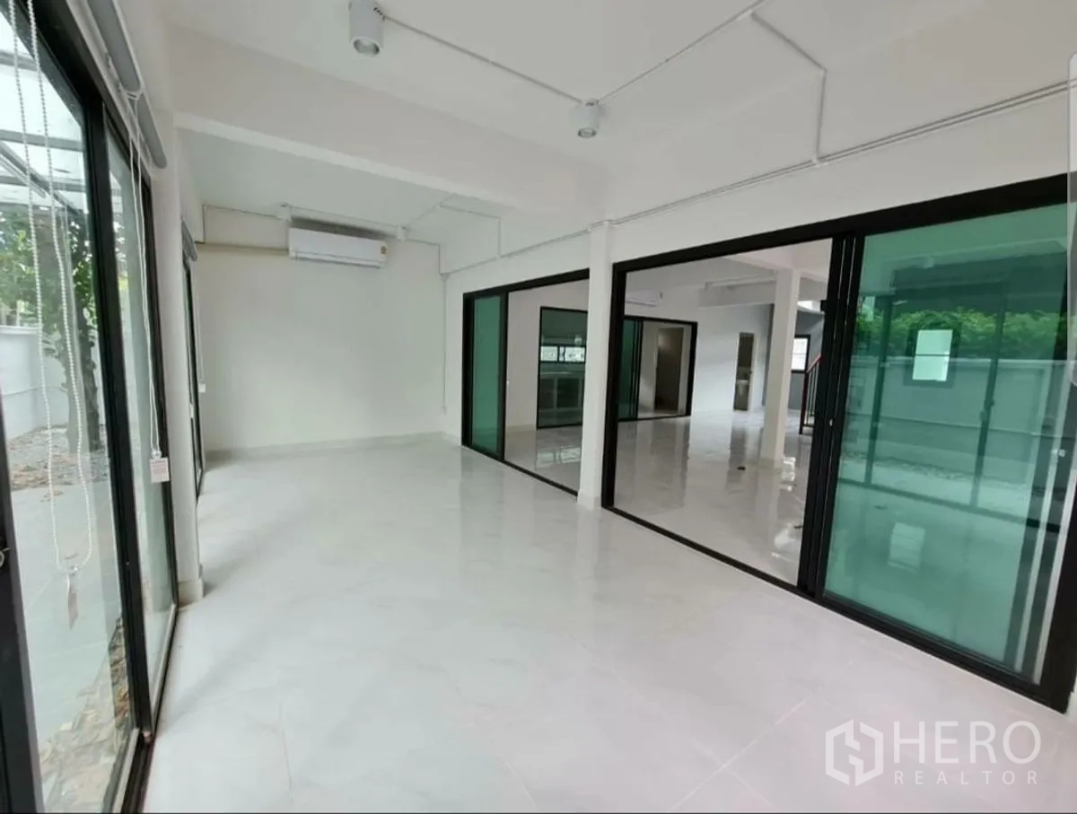 Home Office for rent in Lat Phrao, Bangkok - Bright multipurpose room separated by floor‑to‑ceiling sliding glass panels.
