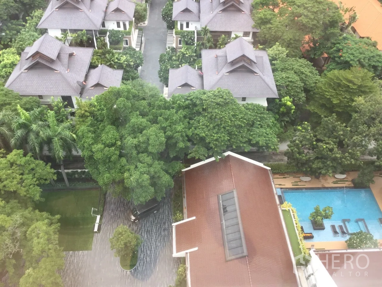 Condominium for rent in Khlong Toei, Bangkok - High-floor view of landscaped garden, swimming pool and low-rise villas within the complex.