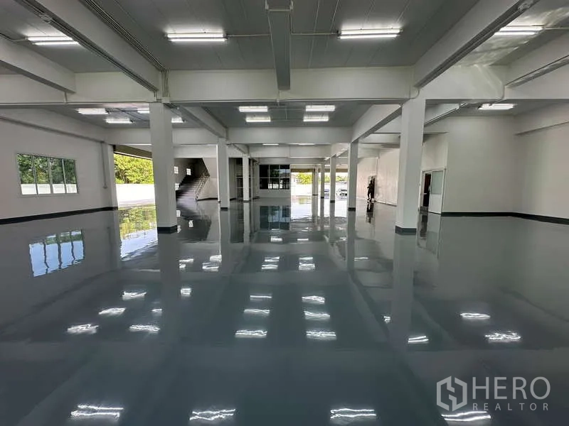 Warehouse for rent in Mueang Samut Prakan, Samut Prakan - Polished epoxy-floored warehouse hall with high ceiling, columns and bright LED lighting.