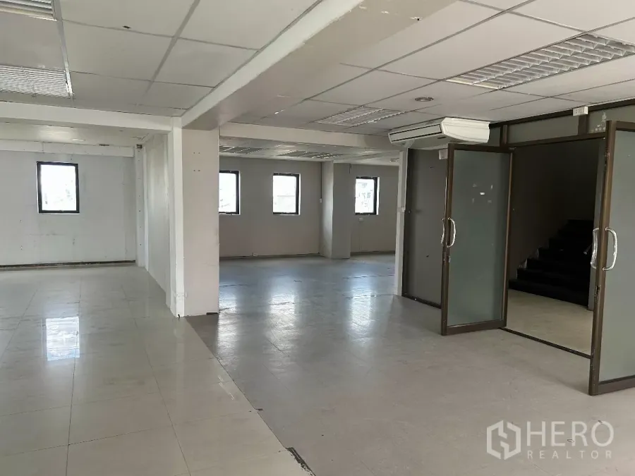 Office Space for rent in Din Daeng, Bangkok - Spacious office interior with partitioned glass doors, an air‑conditioning unit and a staircase.