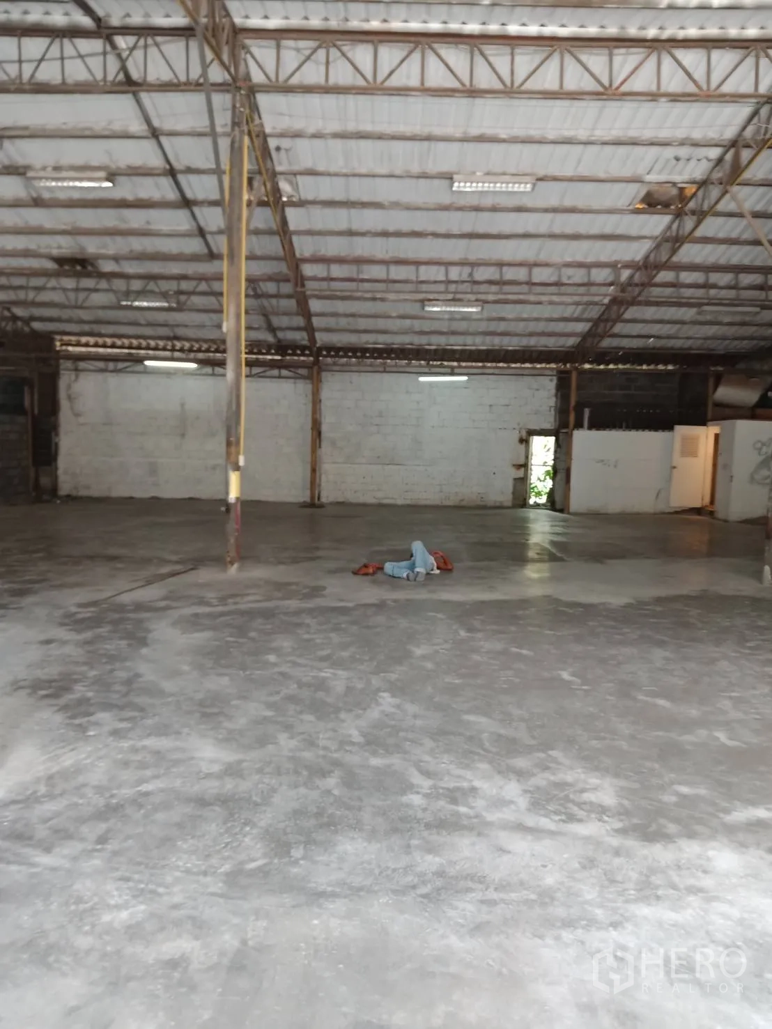 Warehouse for rent in Sai Mai, Bangkok - Wide warehouse hall with high ceiling, central support columns and ample lighting on a concrete slab.