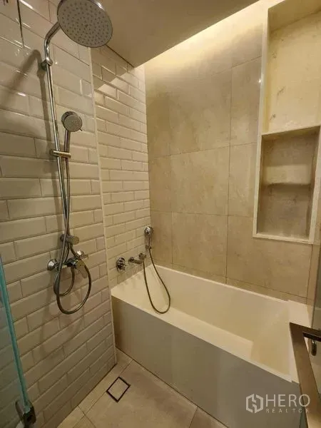 Condominium for rent in Khlong Toei, Bangkok - Modern bathroom with bathtub, rain shower and subway tiles in Ekkamai condo.