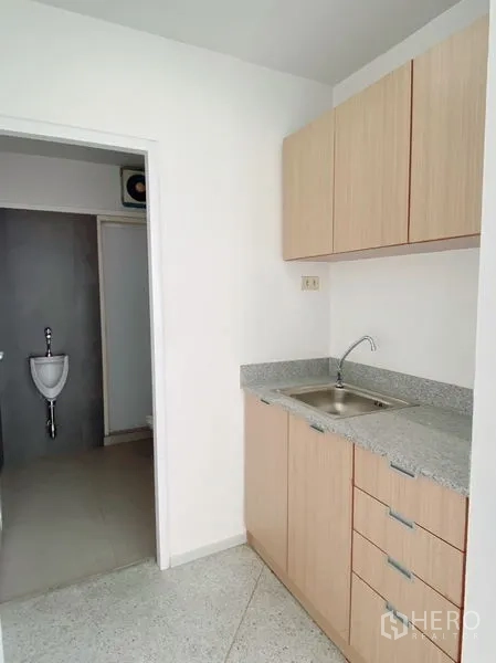 Office Space for rent in Chatuchak, Bangkok - Compact pantry with sink and cabinets beside a private restroom inside the office.