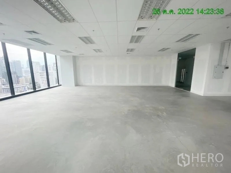 Office Space for rent in Ratchathewi, Bangkok - Bright open‑plan office with floor‑to‑ceiling windows, suspended ceiling lights, and panoramic Bangkok skyline views.