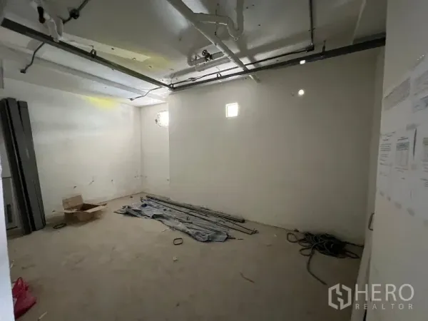 Retail Space for rent in Watthana, Bangkok - Spacious storage or office room in shell condition with visible utility lines.