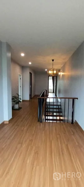 Townhouse for rent or sale in Saphan Sung, Bangkok - Front facade of a three-storey townhouse with wide metal sliding gates.