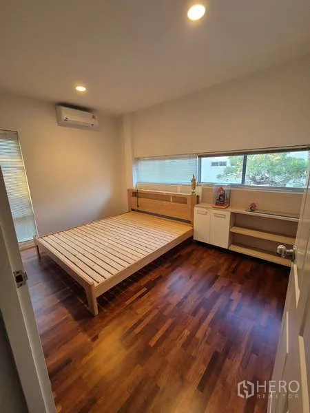 Detached House for rent in Bang Kruai, Nonthaburi - Cozy bedroom with wooden bed frame, built-in shelves and long horizontal window.