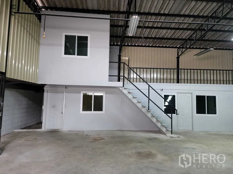 Warehouse for rent in Chatuchak, Bangkok - Close view of mezzanine office above ground-floor rooms with straight metal staircase.