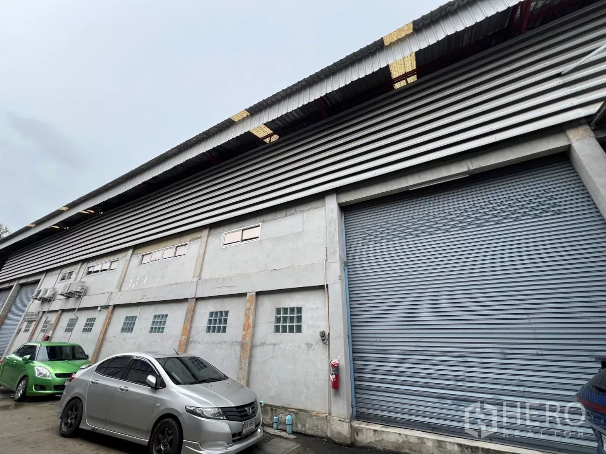 货栈 出租在Khlong Sam Wa, Bangkok - 临街立面，多个卷帘门并配有停车位。