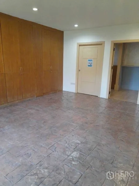 Shophouse for rent in Huai Khwang, Bangkok - Private room with built-in wooden wardrobes and textured tile floor.