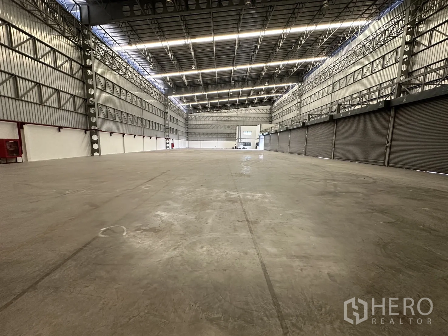 Warehouse for rent in Lat Krabang, Bangkok - Row of roller shutters along the loading side inside the warehouse.