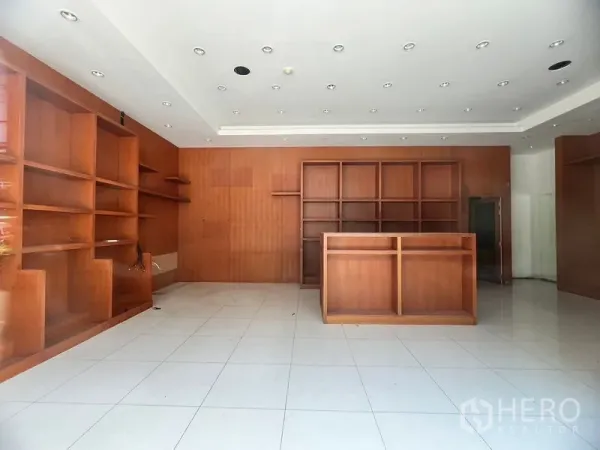 Retail Space for rent in Khlong Toei, Bangkok - Retail storefront interior featuring extensive wood display shelves, service counter, and recessed ceiling lights.