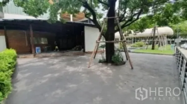 Retail Space for rent in Khlong Toei, Bangkok - Shaded courtyard with large tree, paved driveway, and low-rise retail building.