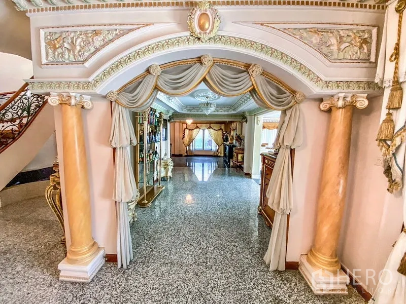 Detached House for rent or sale in Bang Khen, Bangkok - Ornate arched corridor with columns, decorative molding, and glossy stone floors.