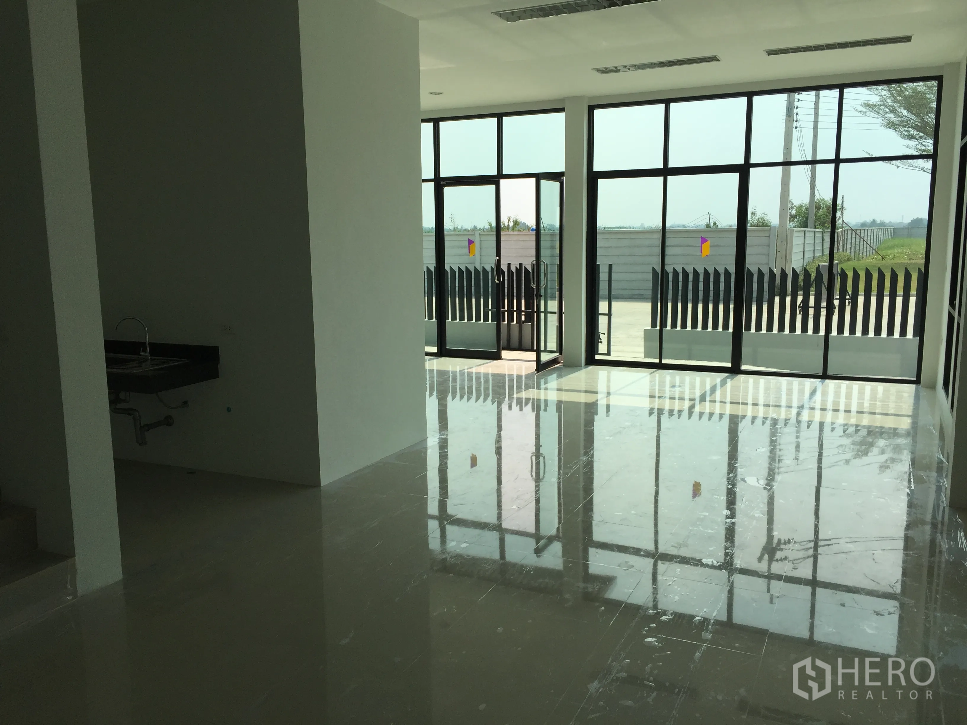 Factory for sale in Lam Luk Ka, Pathum Thani - Office area with sink and floor-to-ceiling glass doors opening to the forecourt.