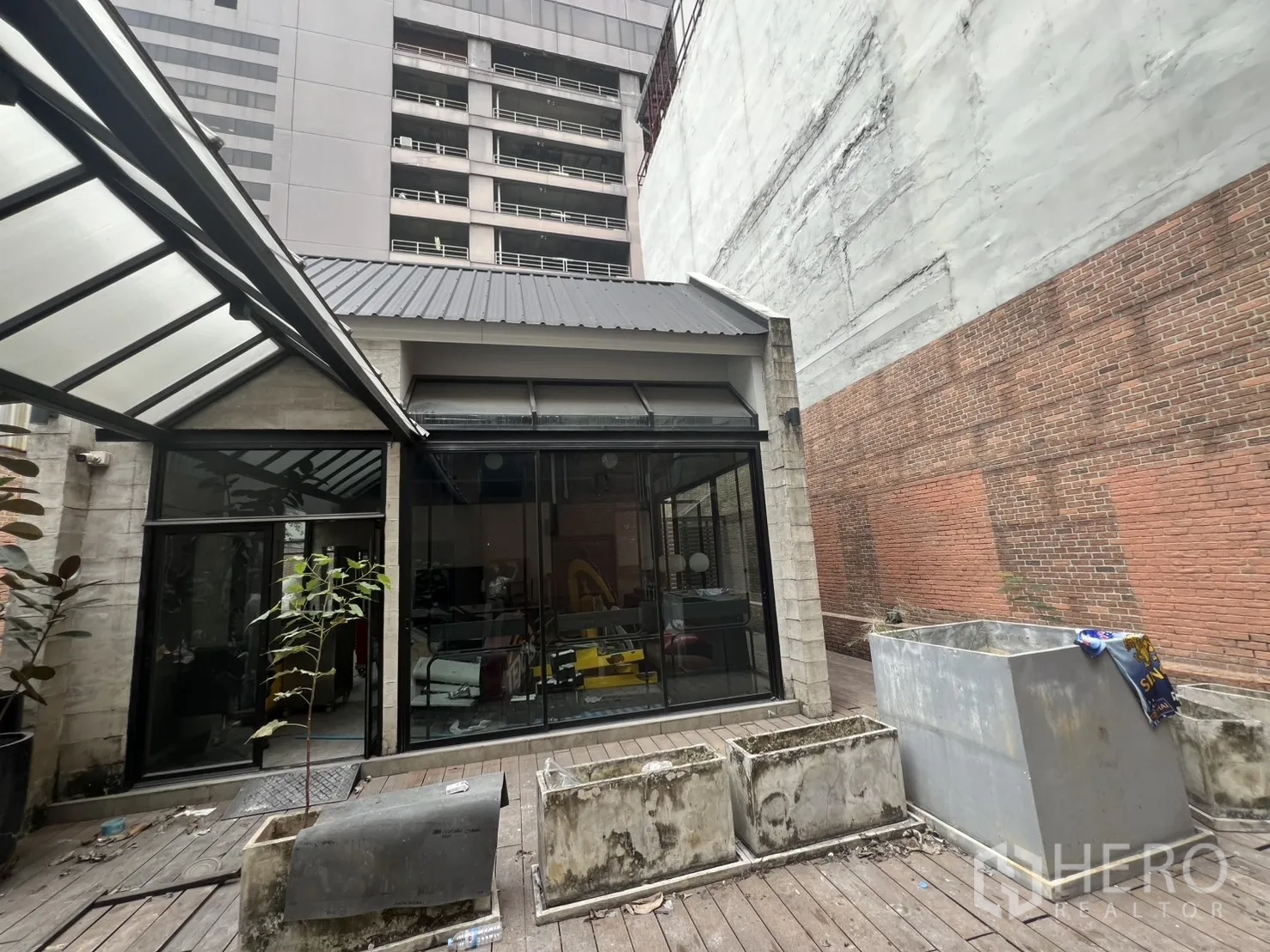 店屋 出租在Bang Rak, Bangkok - 庭院式木平台，玻璃亭与花槽，周围高楼环绕