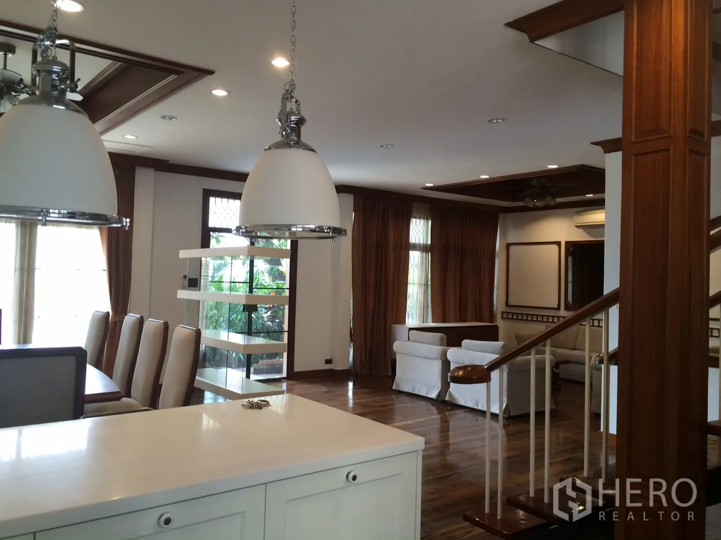 Detached House for rent in Khlong Toei, Bangkok - Open-plan living and dining area with wood floors, pendant lights and garden views in an Ekkamai house.