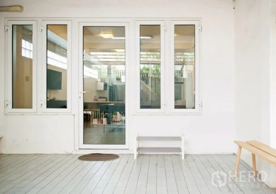 Townhouse for rent in Sathon, Bangkok - Covered front patio with glass door and windows leading indoors.