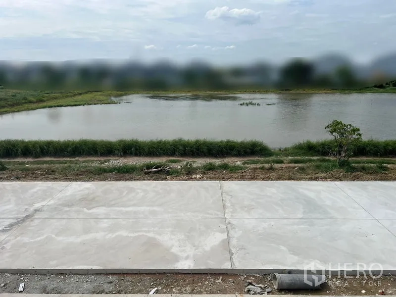 Warehouse for rent in Bang Phli, Samut Prakan - Canal‑side frontage with concrete road in front of the warehouse for truck access.