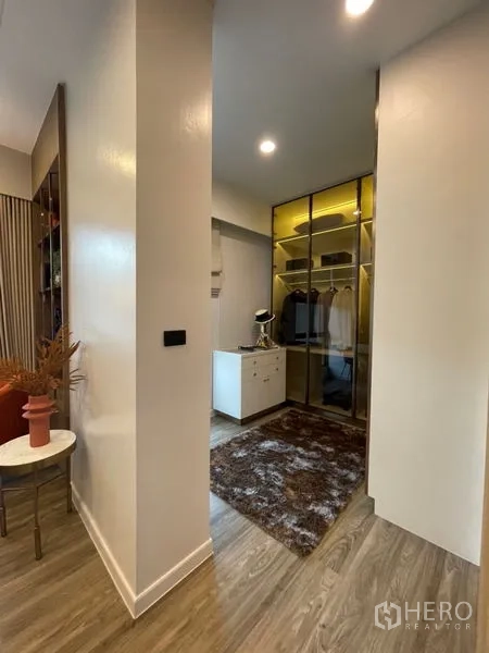 Detached House for sale in Bang Kapi, Bangkok - Walk-in closet with glass wardrobes, center island and warm lighting.