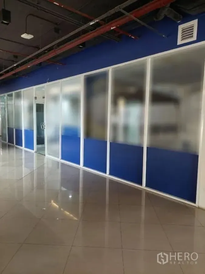 Retail Space for rent in Sathon, Bangkok - Long glass storefront with blue lower panels along an indoor corridor.
