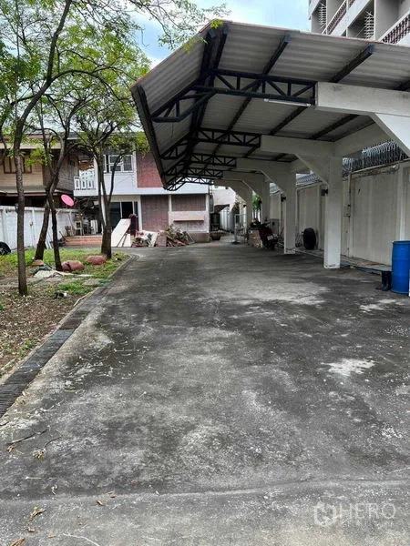 独立式住宅 出租在Sathon, Bangkok - 入口处的混凝土车道与金属屋顶车棚。