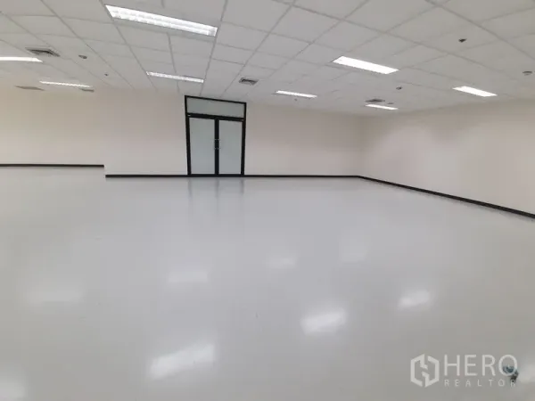 Office Space for rent in Bang Rak, Bangkok - Empty office interior facing a glass door with white walls and drop‑ceiling lighting.