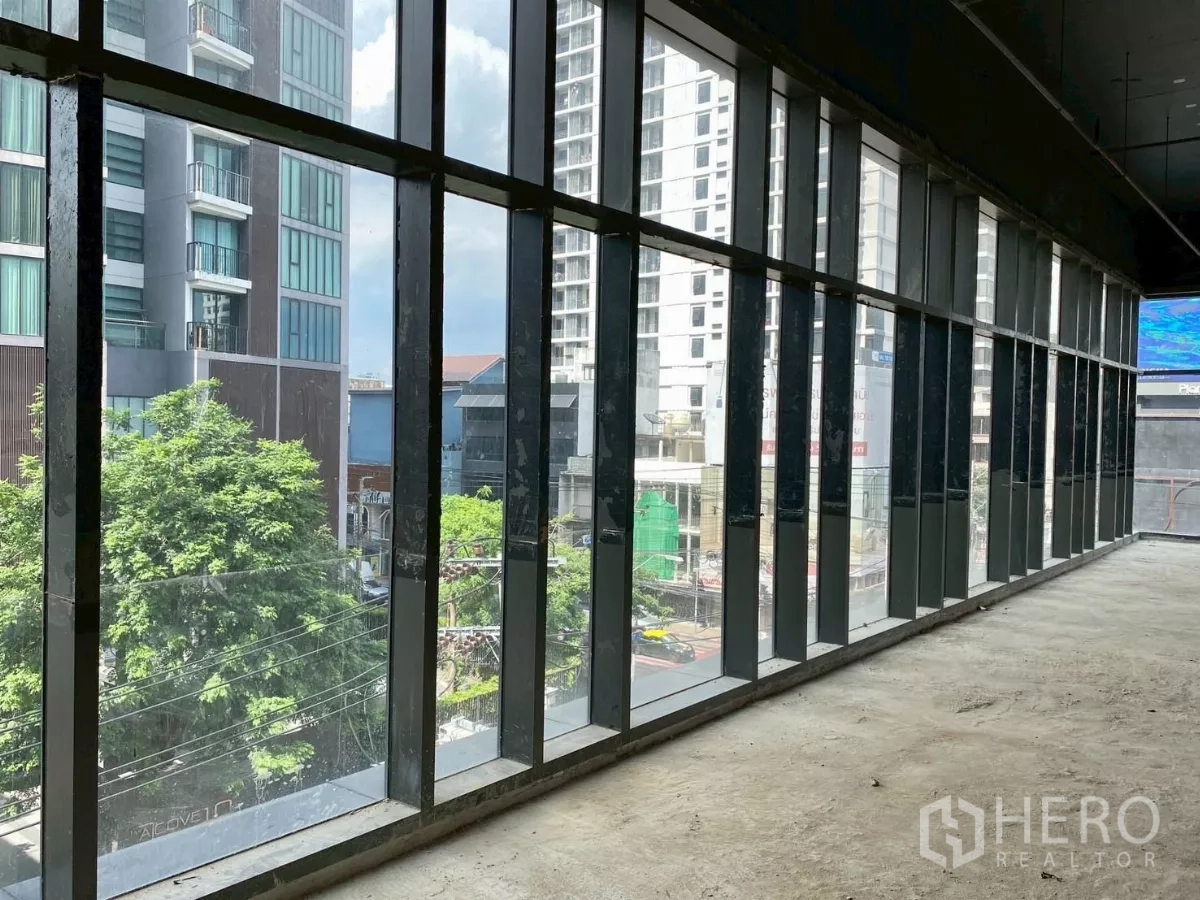 Retail Space for rent - Long wall of full-height windows overlooking trees and high-rise buildings.