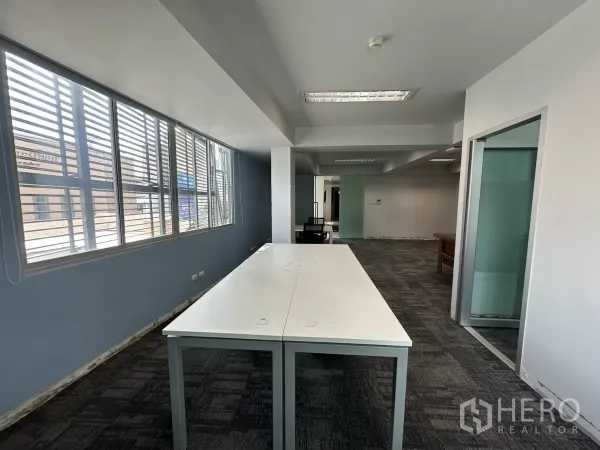 Office Space for rent in Watthana, Bangkok - Row of louvered windows bringing daylight into an open office area with workstations.