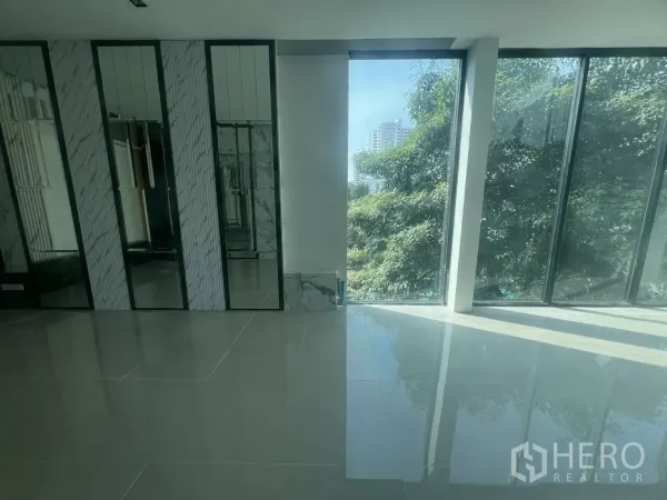 Retail Space for rent in Watthana, Bangkok - Bright retail interior with glossy tiles, mirrored feature wall and floor-to-ceiling windows with city and tree views.