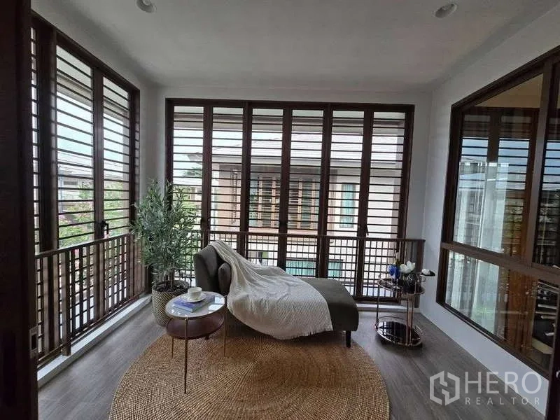 Detached House for rent in Bang Kapi, Bangkok - Enclosed sunroom balcony with full-height louvered windows and a lounge chair.