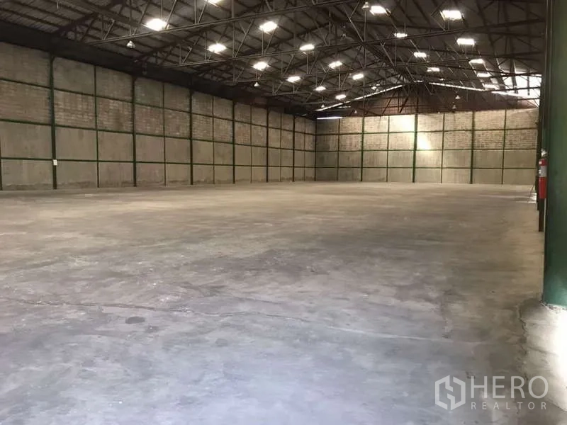 Factory for rent in Bang Pakong, Chachoengsao - Warehouse interior with open floor plate, roof lights and a wall-mounted fire extinguisher.