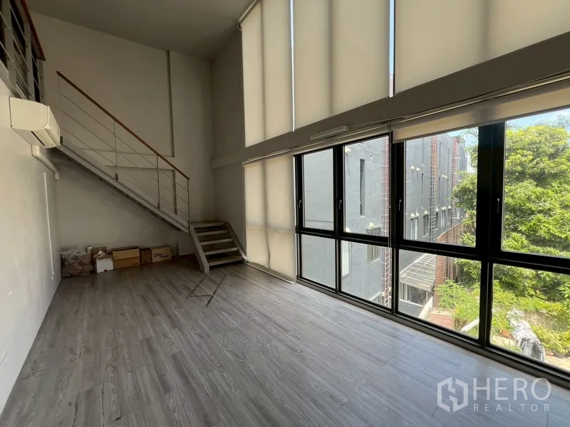 Home Office for rent or sale in Phra Khanong, Bangkok - Mezzanine studio room with tall windows and staircase.