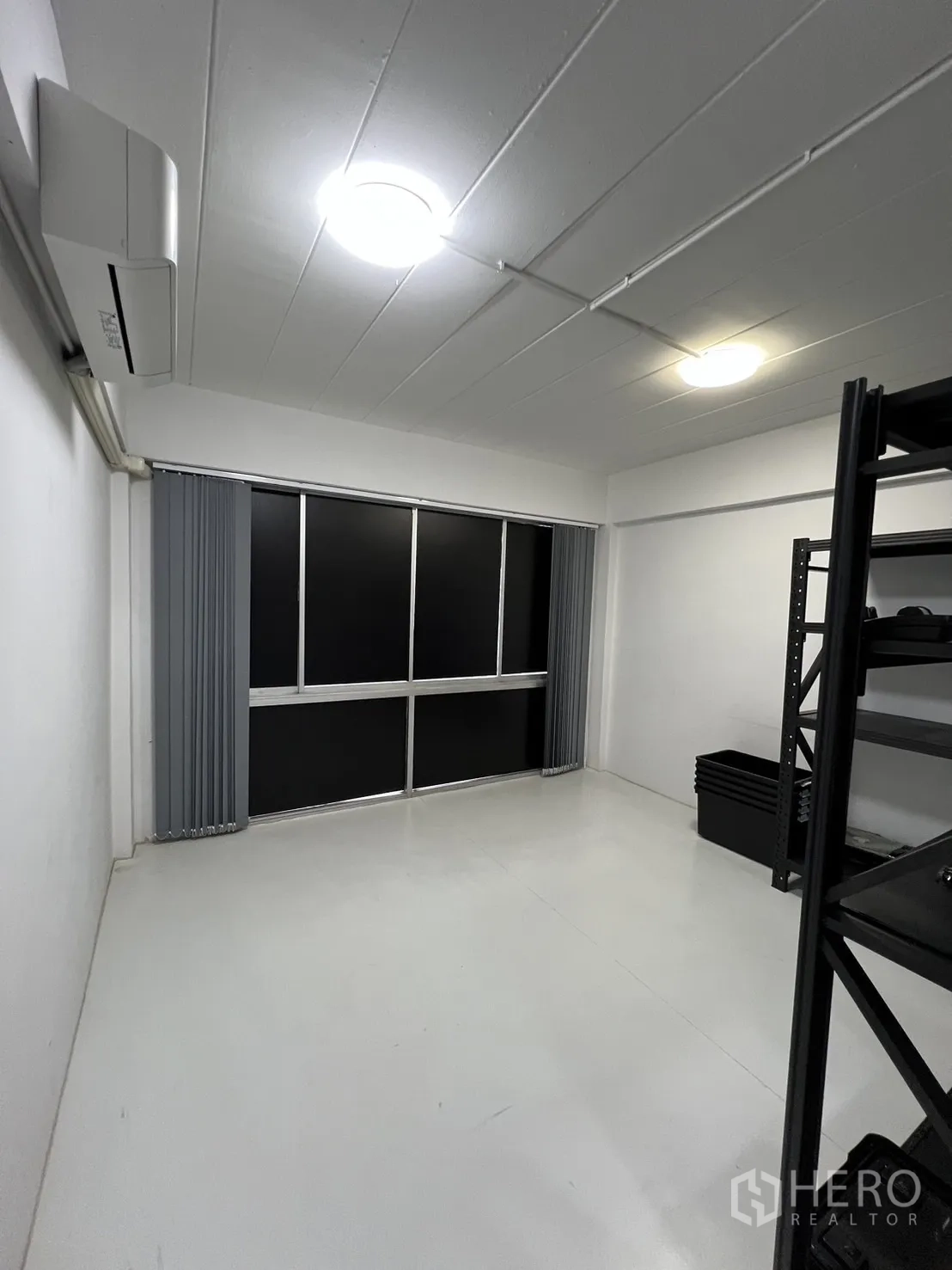 Shophouse for rent or sale in Watthana, Bangkok - Simple room with large window, air-conditioner and vertical blinds.
