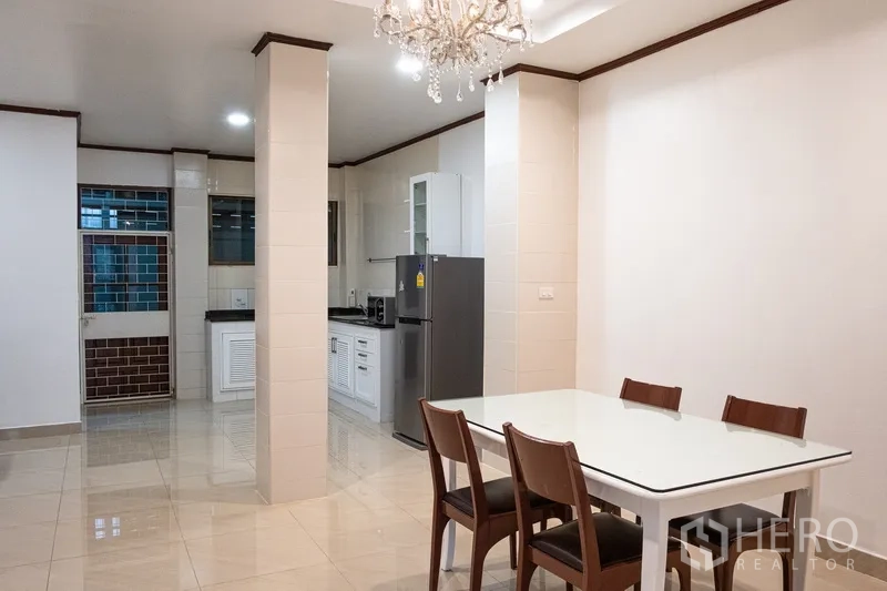 带办公室的家 出租在Khlong Toei, Bangkok - 明亮的餐区，水晶吊灯旁连接整体厨房。