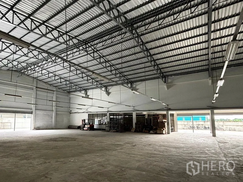 货栈 出租在Bang Khun Thian, Bangkok - 仓库内部空间开阔，钢结构高屋顶与混凝土地面，装卸通道通畅。
